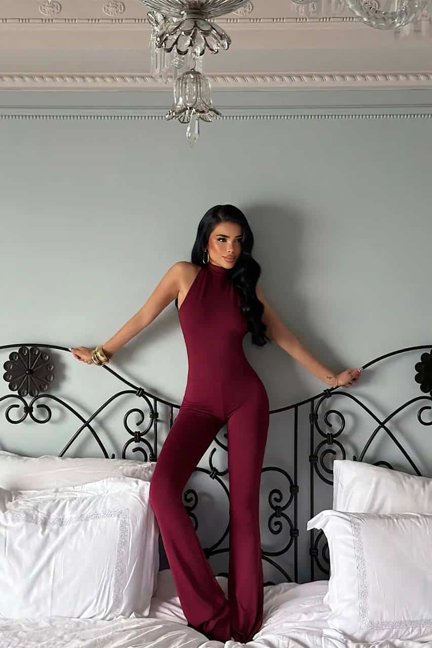 Femme portant une combinaison halter bordeaux élégante et moderne.