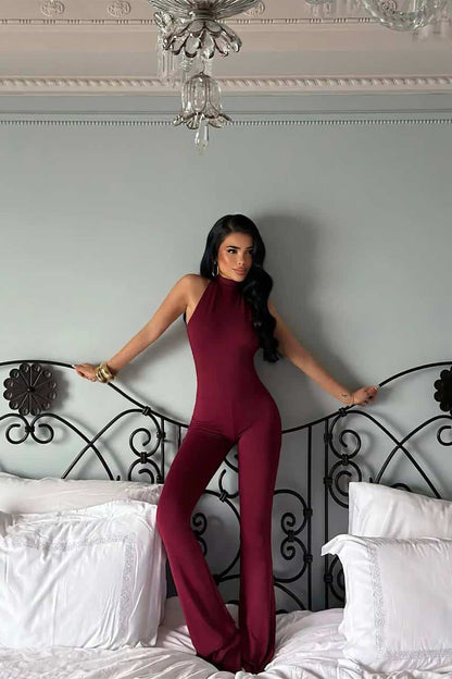 Femme portant une combinaison halter bordeaux élégante et moderne.